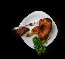 baked chicken on a plate, on a black background