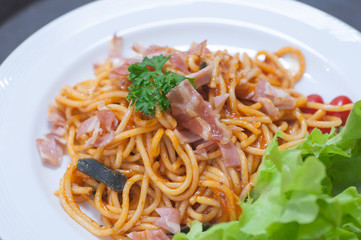 close up of delicious spaghetti with bacon and tomatoes on white plate and , Select focus