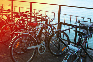 Several bicycles in the parking near the pond