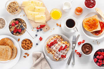 breakfast with granola berry nuts, waffle, toast, jam, chocolate spread and coffee. Top view