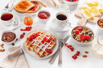 breakfast with granola berry nuts, waffle, toast, jam, chocolate spread and coffee