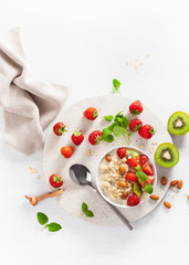 healthy breakfast oatmeal porridge, strawberry, nuts. Top view