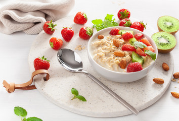 healthy breakfast oatmeal porridge, strawberry, nuts. Top view