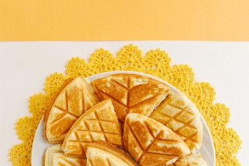 Homemade cookies, handmade on a yellow crocheted napkin. White and yellow background. Background layout with free space for text. The concept of a warm home, comfort.