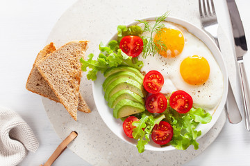 healthy breakfast flat lay. fried eggs, avocado, tomato, toasts