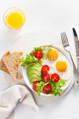 healthy breakfast flat lay. fried eggs, avocado, tomato, toasts