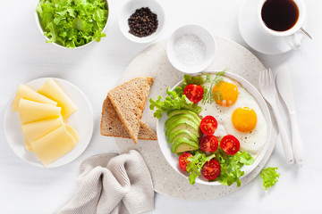 healthy breakfast flat lay. fried eggs, avocado, tomato, toasts and coffee