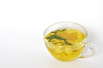Photo of herbal tea in a transparent cup. flowers and leaves of herbs. flowers of linden and elderberry, leaves of mint. time for relaxation. hot tea. use for background, text, for your design, card
