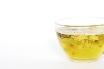 Photo of herbal tea in a transparent cup. flowers and leaves of herbs. flowers of linden and elderberry, leaves of mint. time for relaxation. hot tea. use for background, text, for your design, card