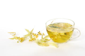 Photo of herbal tea in a transparent cup. flowers and leaves of herbs. flowers of linden and elderberry, leaves of mint. time for relaxation. hot tea. use for background, text, for your design, card