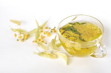Photo of herbal tea in a transparent cup. flowers and leaves of herbs. flowers of linden and elderberry, leaves of mint. time for relaxation. hot tea. use for background, text, for your design, card
