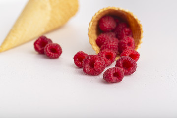Ice cream or delicious dessert made from fresh raspberry berries on white background. Raspberry in a waffle cone. Summer, freshness, and the concept of the sweet menu.