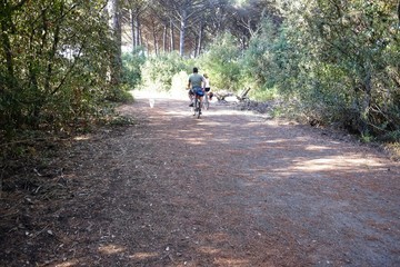 Obraz premium man on a bike in the park with a dog