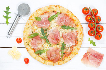 Pizza Prosciutto Schinken Zutaten backen von oben auf Holzbrett