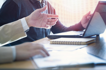 Businessman is deeply reviewing a financial report for a return on investment or investment risk analysis on a laptop computer notebook.