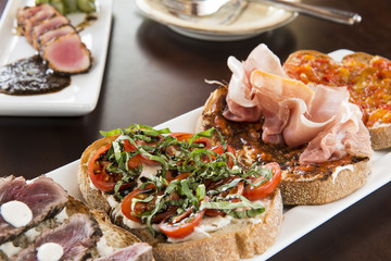 Bruschetta with Cream Cheese, Meat, Tomatos, on a White Plate