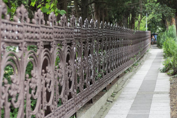 Old cast iron spiked fence in a city park