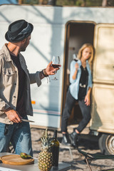 Obraz premium selective focus of man with glass of wine looking at girlfriend near campervan