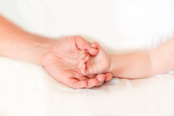 Father holding the hand of his new born son