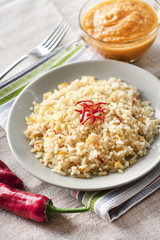 Fototapeta na wymiar Spicy parboiled rice with carrots, yellow zucchini and chilli peppers