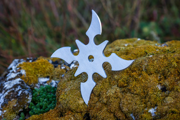 Shuriken (throwing star), traditional japanese ninja cold weapon stuck in wooden background