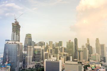 Fototapeta premium Aerial view of Singapore business district with buildings under construction near city center. Modern Asian cityscape at sunset