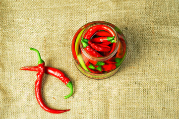 Marinated hot chili pepper in a glass jar. Home blanks