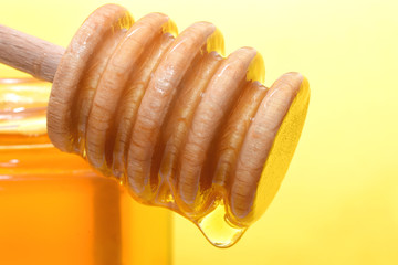 Honey is pouring from dipper closed up