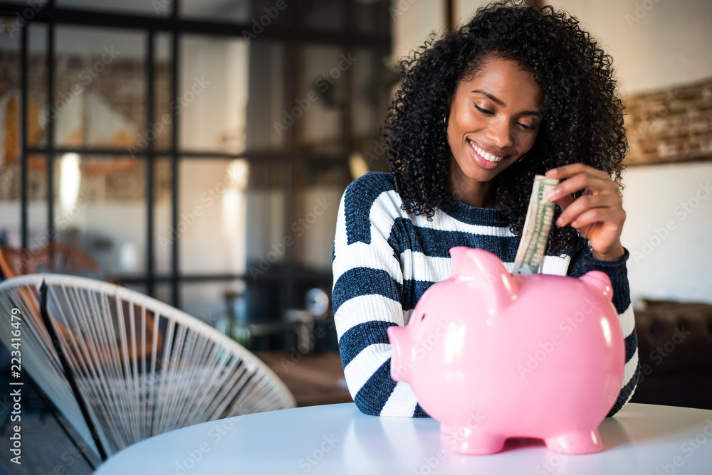 Wall mural black woman with saving piggy bank