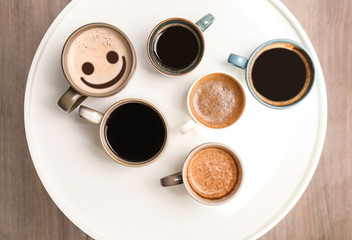 Many cups of different aromatic hot coffee on table, top view