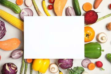 Flat lay composition with fresh vegetables and blank card for text on light background