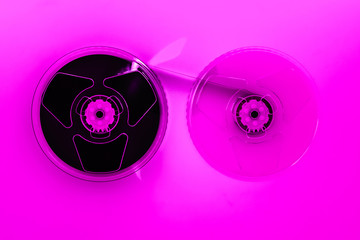 Abstract composition of video home system VHS tape reels in pink color effect