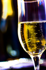 Party concept. Full glass of champagne with party lights background.