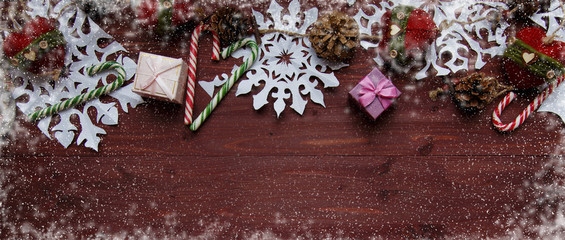 New Year's Christmas concept. Snowflakes cut from paper, gifts, scissors on a wooden table