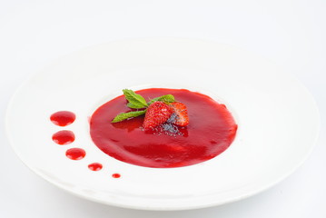 Strawberry mousse with mint on a white plate