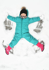 Fototapeta na wymiar Little girl plays outdoor with a snow. 