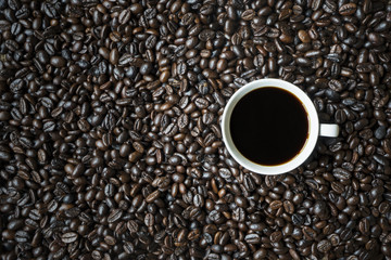 Black coffee above roasted coffee beans