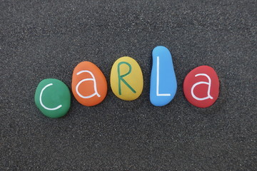 Carla, feminine give name with colored stone letters over black volcanic sand
