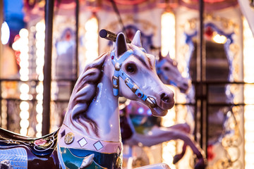 Brilliant vintage merry-go-round wooden horses against the background of Children's Carousel at...