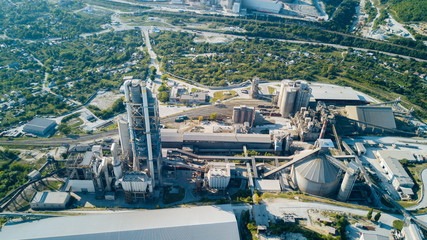 Fototapeta premium Aerial view of cement manufacturing plant. Concept of buildings at the factory, steel pipes, giants.