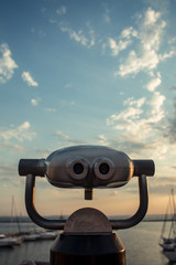Sunrise in the port through binoculars at the viewing platform view of the sea with yachts overlooking the horizon