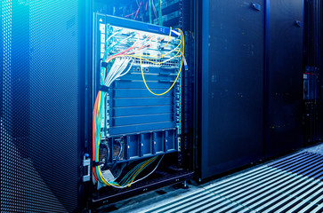 Image presents a bottom view of a room equipped with data servers. Blue LED lights are flashing.