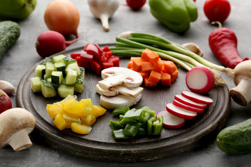 Fresh sliced vegetables on brown cutting board