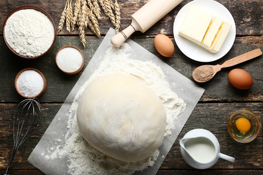 Raw dough with butter, flour and eggs on wooden table