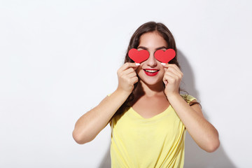 Young woman holding red paper hearts on white background