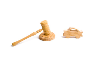 Wooden figurine of a car in the hammer of a judge on a white background. Minimalism. Purchase and sale of the car. The trial, confiscation of the machine. Recognition of ownership.