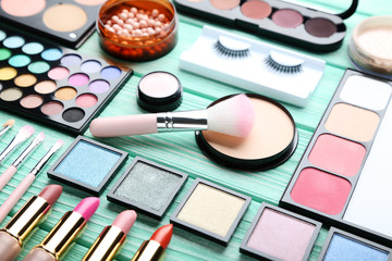 Obraz na płótnie Canvas Different makeup cosmetics on mint wooden table