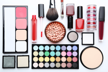 Makeup brush and different cosmetics on white background