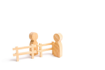 A wooden fence divides the two groups discussing the case. Termination and breakdown of relations, breaking ties. Contract break, conflict of interests. Negotiations of businessmen.