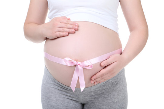 Pregnant woman with pink ribbon on white background